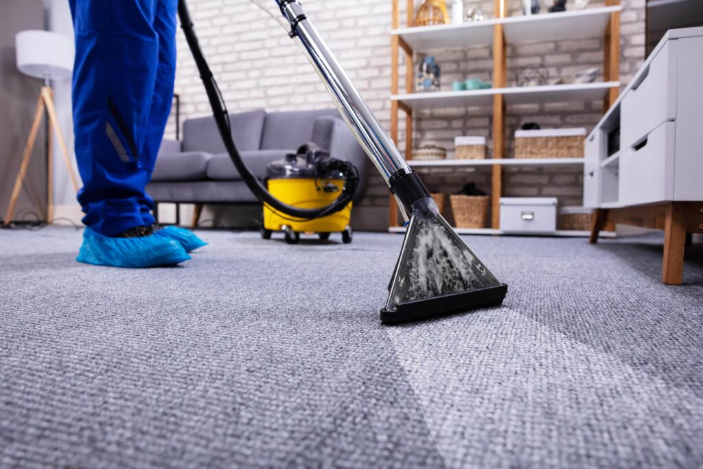 person-cleaning-carpet-with-vacuum-cleaner-min